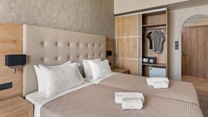 A hotel room with a large bed, a wardrobe, a desk, and a nightstand. - Stefania Beach Resort (Eretria)