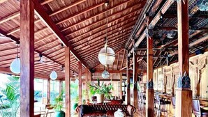 A spacious room with a wooden ceiling, a leather sofa, and hanging light fixtures. - La Coralina Island House -only Adults (Bocas del Toro)