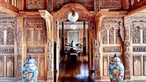 A grand hall with intricate wooden carvings, a chandelier, and large vases. - La Coralina Island House -only Adults (Bocas del Toro)