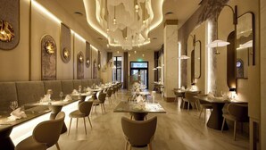 Un restaurant spacieux avec de longues tables, des lustres modernes et un décor contemporain.