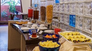 Un buffet proposant une variété de plats, agrémenté d’un mur décoratif recouvert de carreaux bleus et blancs.
