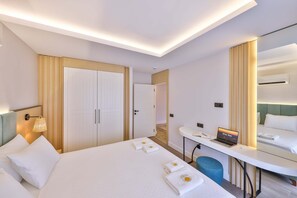 Une chambre d  ’hôtel avec un lit, un bureau avec un ordinateur portable, un miroir et une porte.