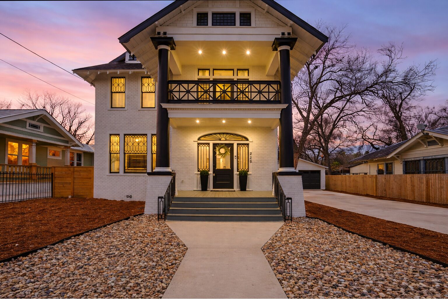 A two-story house with a balcony, a front porch, and a driveway.