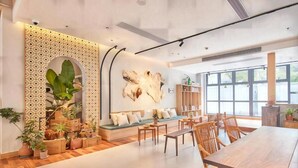A modern interior with a wooden dining table, a sofa with cushions, and a large window providing natural light. - Yitel Hotel Shanghai Hongqiao Airport Lianming Road Branch (Shanghai)
