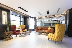 Een moderne zithoek met een bank, fauteuils en een salontafel.