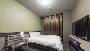 Une chambre d’hôtel avec un lit, une télévision, un banc et un rideau.