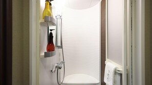 Une salle de bain avec une douche, un porte-serviettes et une étagère contenant des articles de toilette.
