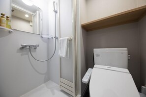 Une salle de bain équipée d’une douche, de toilettes et d’un panneau de commande.