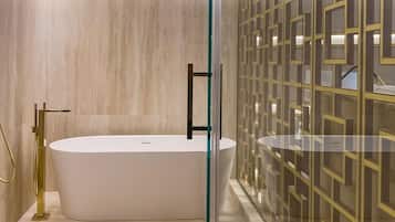 Un baño moderno con una bañera independiente, cabina de ducha con mampara de vidrio y un panel decorativo en la pared.
