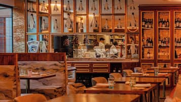 Een restaurant met een bar, houten meubels en een etalage met pinguïnbeeldjes.