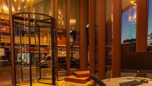 Eine Hotellobby mit einer Drehtür, einem Empfangsbereich und Blick auf die Straße.