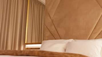 A hotel room with a bed, a large mirror, and curtains.