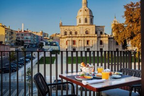 A balcony with a table set for breakfast, overlooking a cityscape with historic architecture. - Wine & Books Lisboa - Wbl (Lisbon)