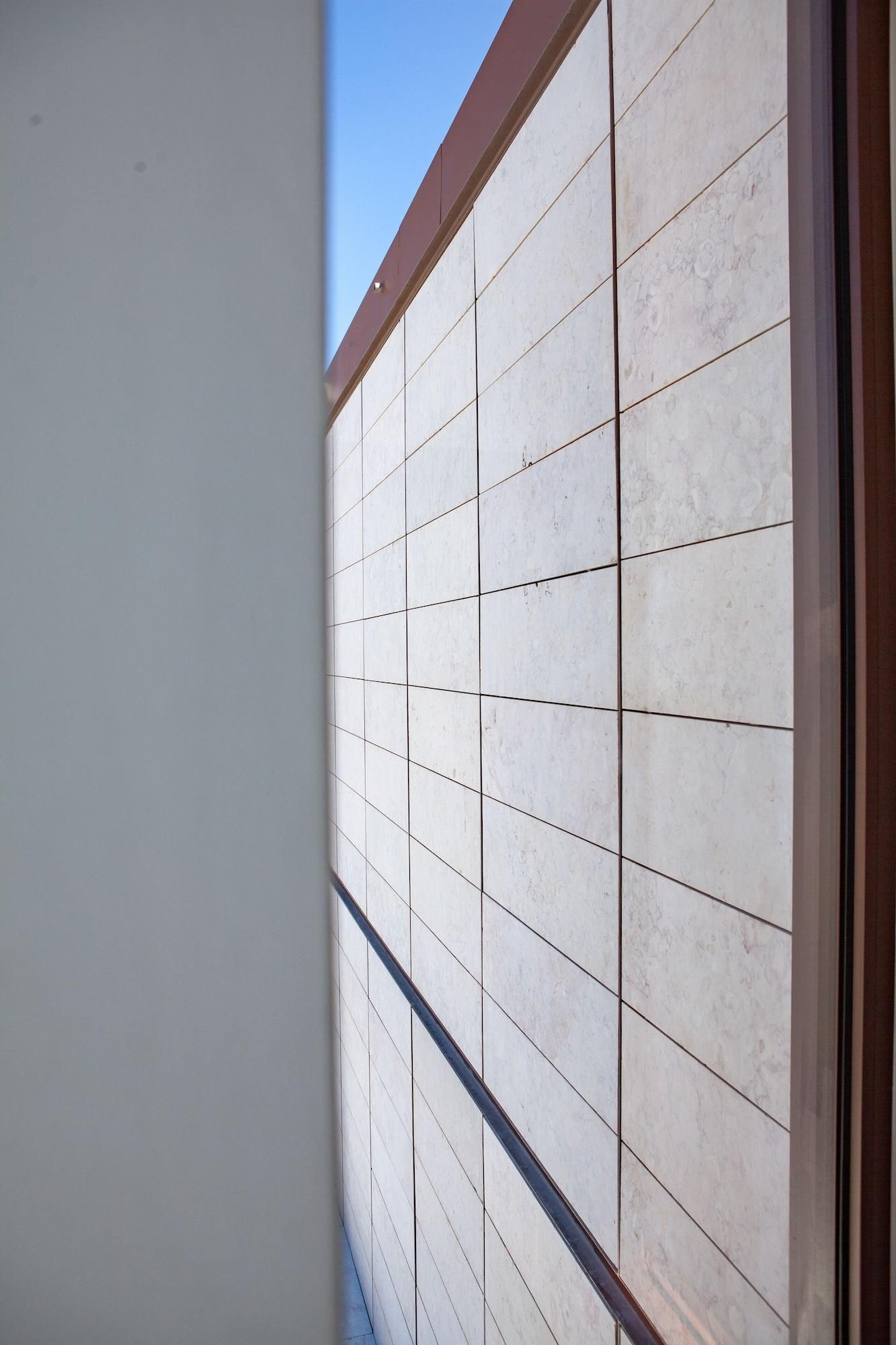 Um corredor com parede revestida de azulejos e moldura de porta em madeira.