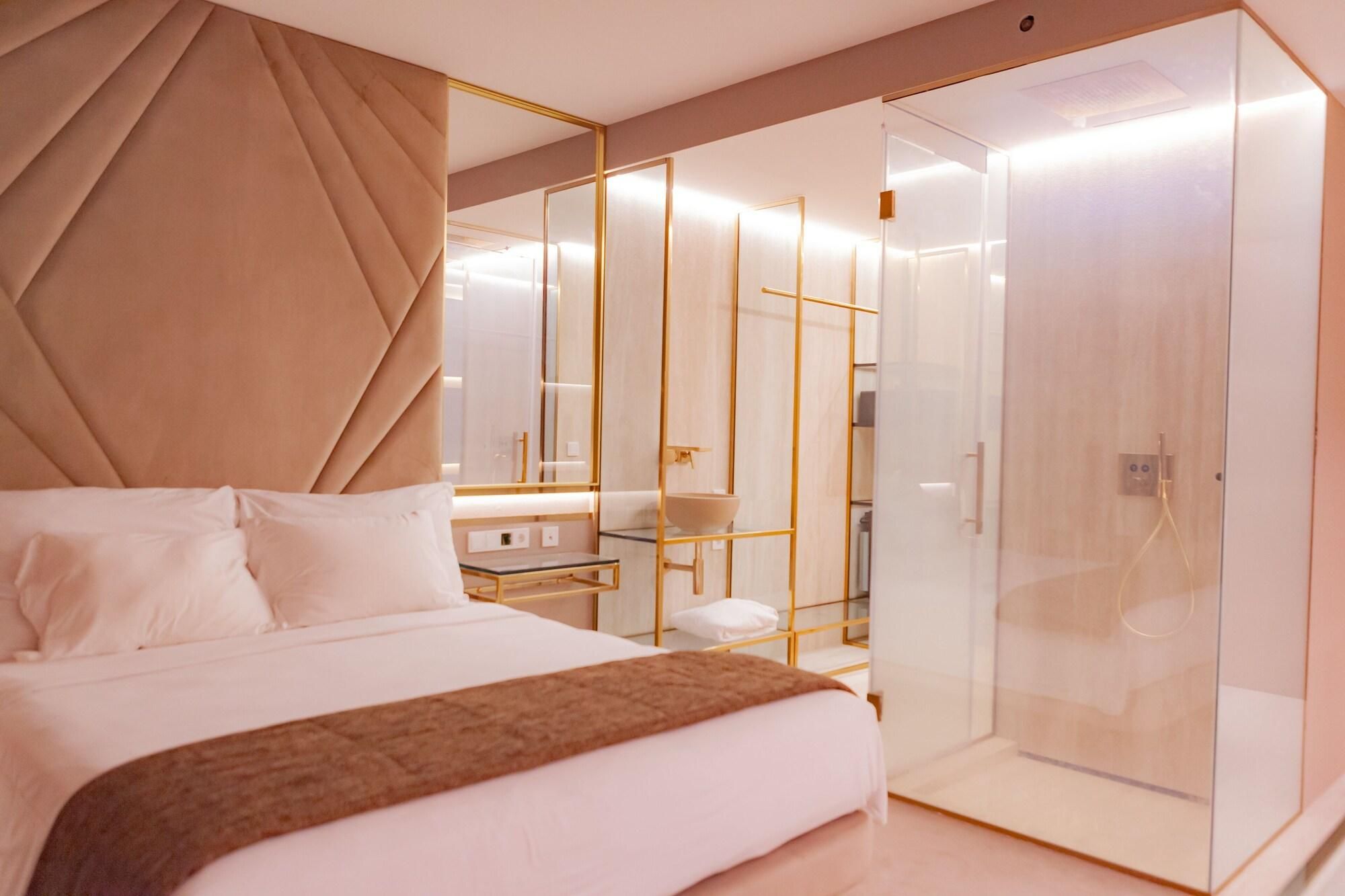 Une chambre à coucher moderne avec un grand lit, une table de chevet, un miroir et un dressing avec douche.