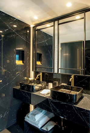 Un baño moderno con dos lavamanos, un espejo grande y un perchero para toallas.