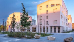 Ein modernes Gebäude mit flachem Dach, großen Fenstern und einer glatten Fassade.