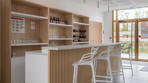 Eine moderne Bar mit Holzböden, weißen Barhocker und einer Glasvitrine.