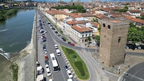 A cityscape with a river, historic buildings, and a prominent tower. - Le Reve De Naim (Florence)