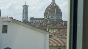 A view of a building with a dome and a tower, likely a historical or religious structure. - Le Reve De Naim (Florence)
