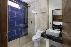 A modern bathroom with a glass-enclosed shower, a white toilet, and a black countertop sink. - Angelina 28 Beachfront by Nah Hotels (Playa del Carmen)
