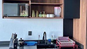 Eine moderne Küche mit integriertem Mikrowellenherd, einer Spüle und einem Geschirrgestell.