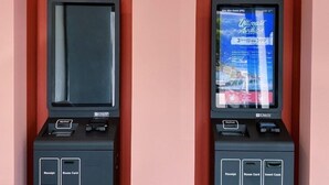 Two self-check-in kiosks with screens displaying a hotel booking interface. - Woco Hotel Kinrara (Puchong)