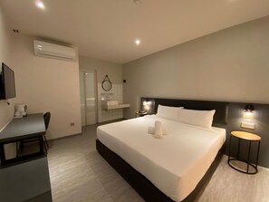 A modern hotel room with a large bed, a desk, a bathroom, and a TV. - Woco Hotel Kinrara (Puchong)