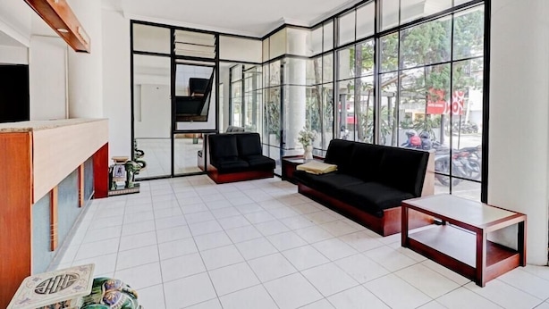 Een moderne receptie met een zwarte bank, een kleine tafel en een receptiebalie.