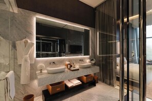 A modern bathroom with a large mirror, two sinks, and a glass shower enclosure. - Hotel Alexander (Mexico City)
