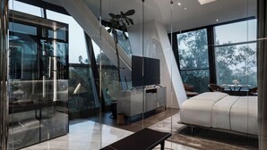 A modern interior with a glass wall, a bench, a sofa, and a dining area with a view. - Hotel Alexander (Mexico City)