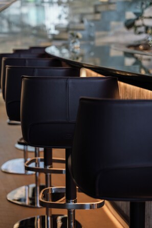 A row of black leather chairs with metal legs, arranged in a row. - Hotel Alexander (Mexico City)