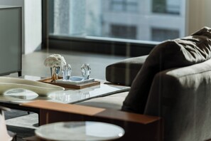 A modern living room with a sofa, a coffee table, and decorative items. - Hotel Alexander (Mexico City)
