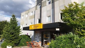 A hotel with a yellow sign reading "Premiere Classe" and a modern architectural design. - Premiere Classe Troyes Sud - Parc St Thibault (Bucheres)