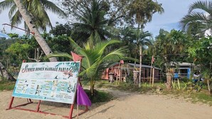 Un salón de masajes frente a la playa, con un letrero que enumera servicios y precios.
