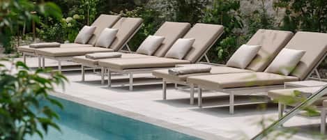 A poolside area with lounge chairs and a clear view of the pool.