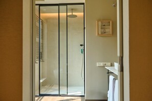 A modern bathroom with a glass shower enclosure, a towel rack, and a framed picture on the wall. - Rhin Garden (Santander)