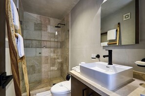 A modern bathroom with a glass-enclosed shower, a white sink, and a wooden vanity. - Bakal Tulum By Lockey (Tulum)
