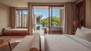 A modern hotel room with a balcony, a bed, a sofa, and a small table. - Cocana Resort (Gili Trawangan)