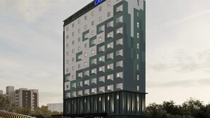 Un grand hôtel, reconnaissable à son enseigne « CBN Express », qui se distingue par son architecture moderne, ses nombreux étages et son entrée imposante.
