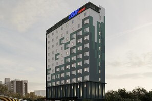 Un grand hôtel, reconnaissable à son enseigne « CBN Express », qui se distingue par son architecture moderne, ses nombreux étages et son entrée imposante.