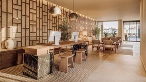 Ein modernes Interieur mit Wandverkleidung aus Holz, einem zentralen Essbereich mit Barhocker und einer Sitzecke mit Stühlen.