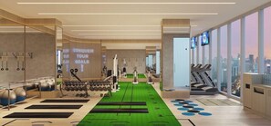 A modern gym with exercise equipment, motivational wall text, and large windows offering city views. - Oakwood Hotel and Apartments Grand Batam (Batam)