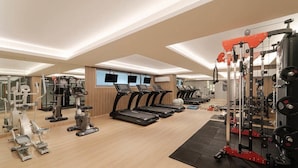 Un gimnasio con cintas de correr, elípticas y equipamiento de levantamiento de pesas.