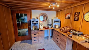Eine kleine Küche mit Holzausstattung, einer Kaffeemaschine, einer Mikrowelle und einem Toaster.