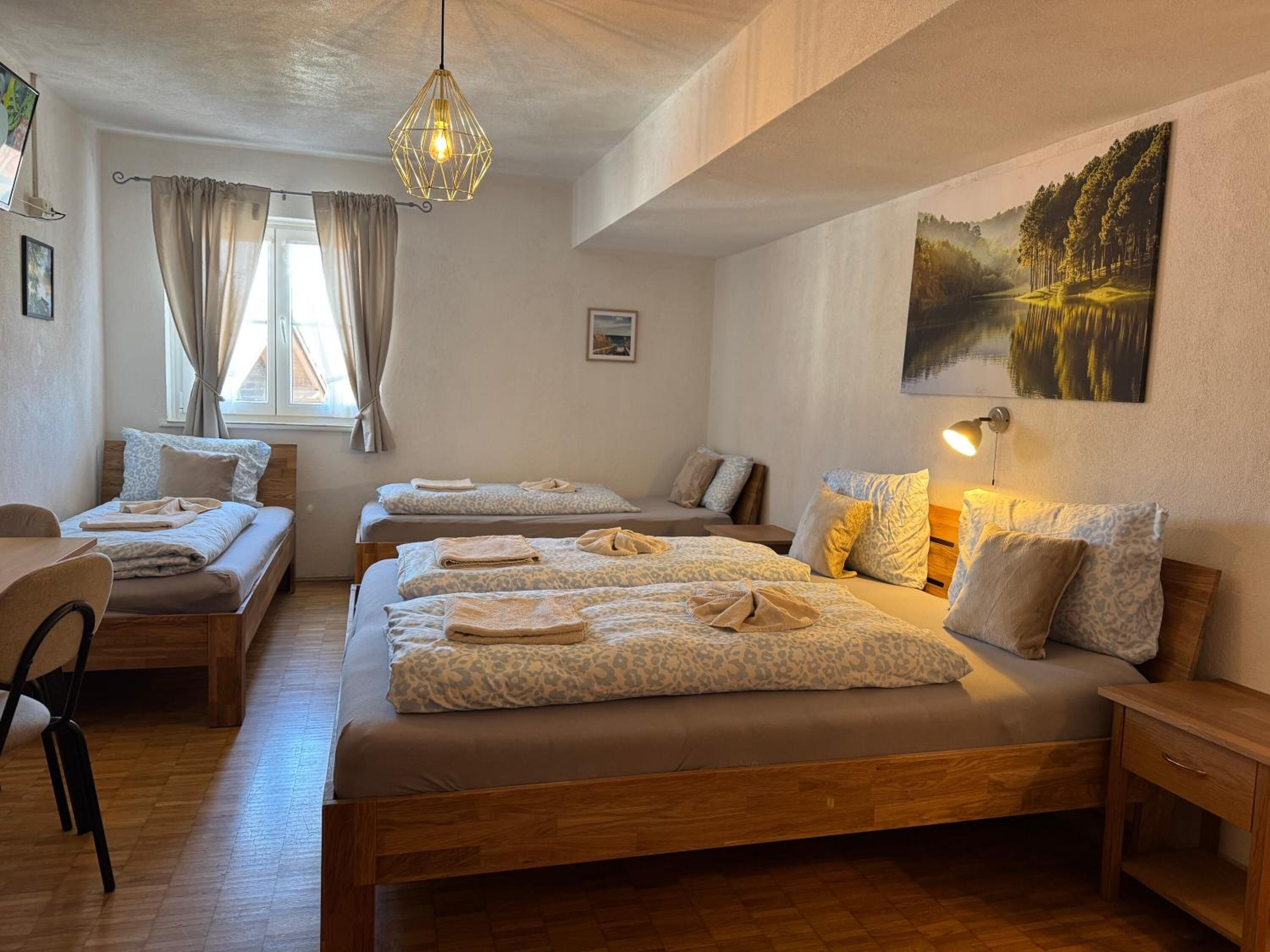 Una habitación de hotel con tres camas, un escritorio y una silla.