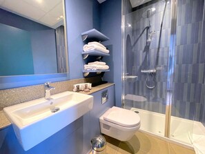 A modern bathroom with a sink, toilet, and shower. - Hex Wildlife Hotel At Yorkshire Wildlife Park (Doncaster)