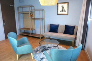 A modern living room with a sofa, two armchairs, a glass coffee table, and a metal shelving unit. - Hex Wildlife Hotel At Yorkshire Wildlife Park (Doncaster)