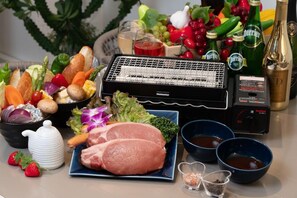 Un plat à fondue préparé avec divers légumes, de la viande et des condiments.