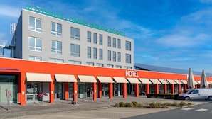 Un hôtel au design moderne, caractérisé par une façade rouge imposante et de nombreuses fenêtres.